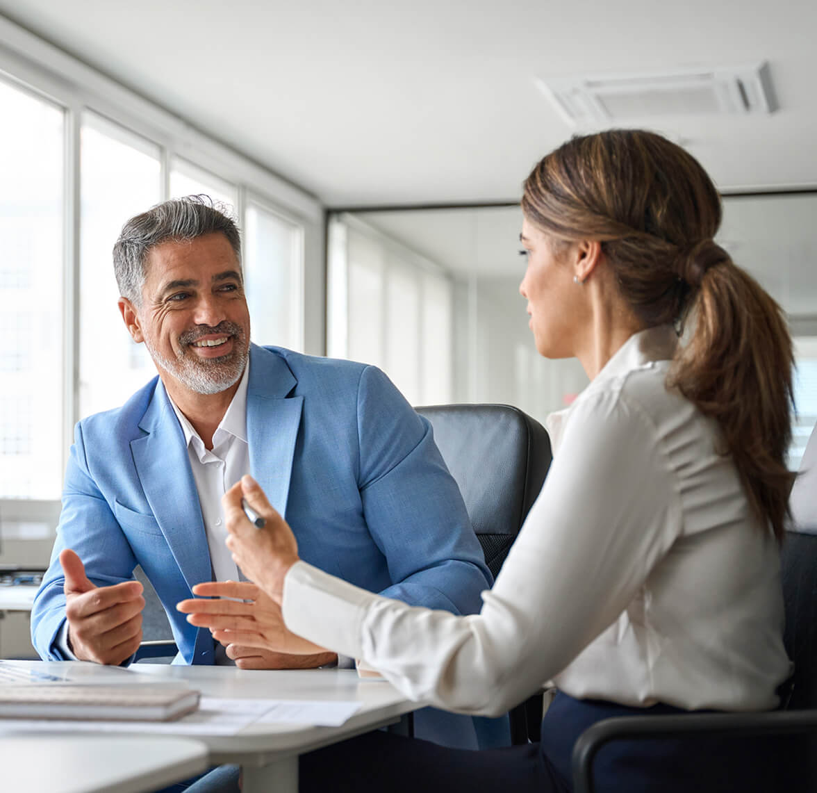Colleagues talking at a desk