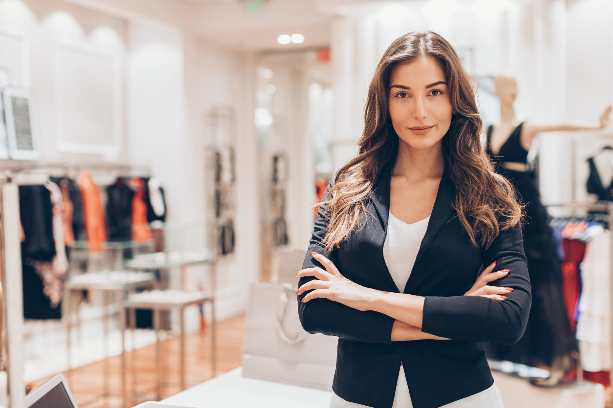 Beautiful woman standing with arms crossed in a fashion store