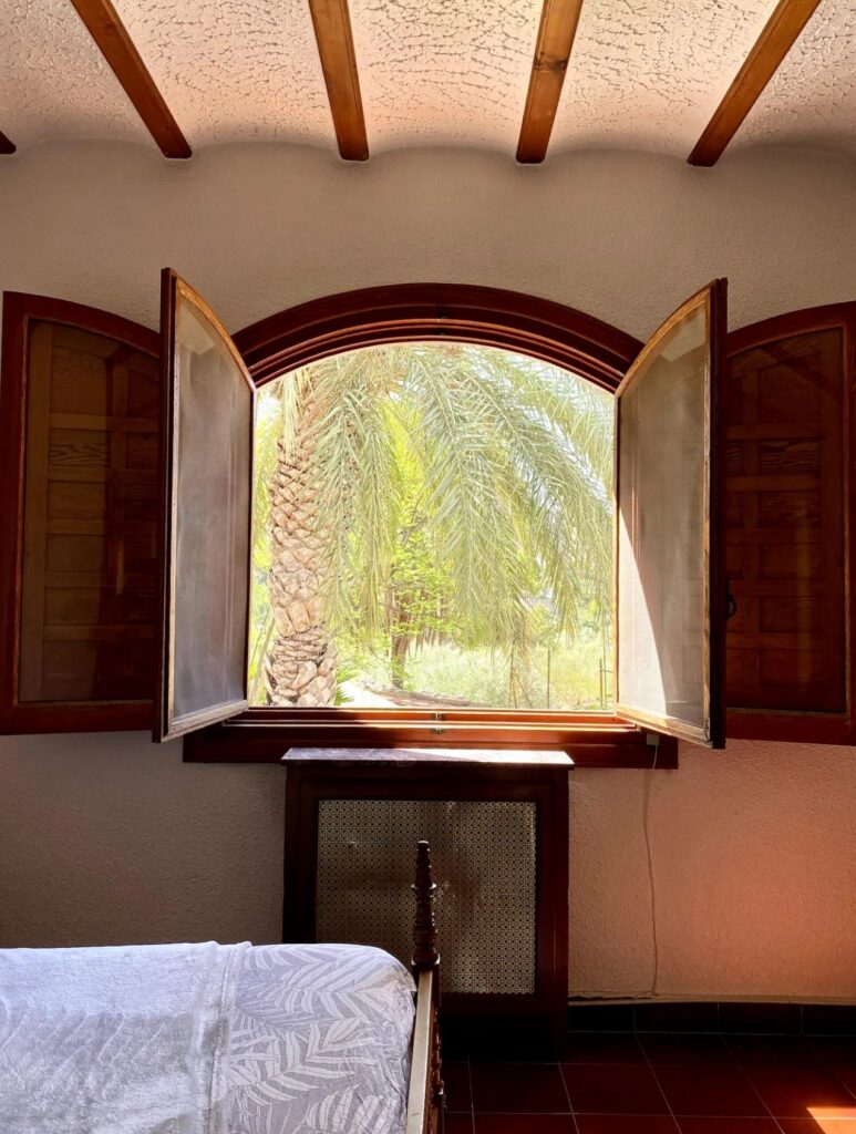 Luxury bedroom with palm tree views at the Divorce to Domination™ Experience in Alicante.