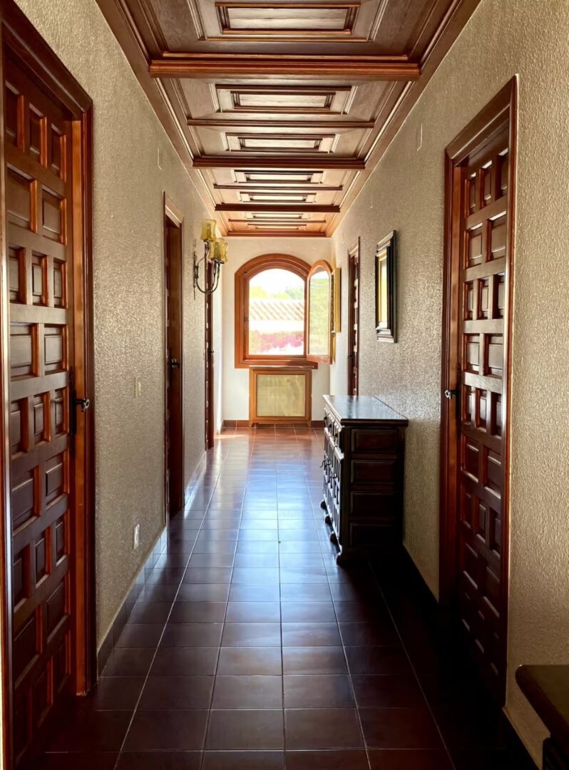 Traditional Spanish villa hallway at the Divorce to Domination Retreat in Alicante with wooden doors and tiled floors