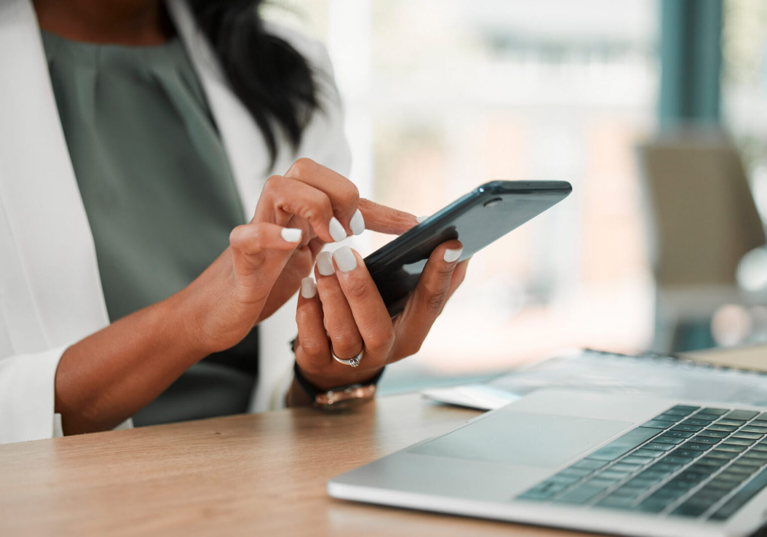 Phone, office and business woman networking on social media, the internet or a mobile app. Technology, corporate and professional company leader browsing on a mobile device in her modern workplace.