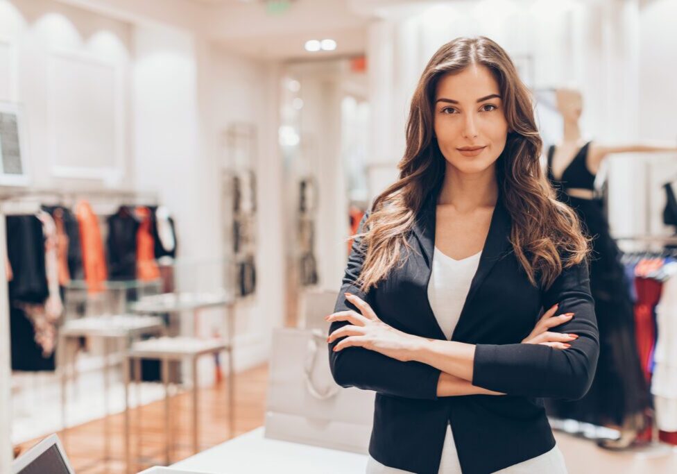 Beautiful woman standing with arms crossed in a fashion store