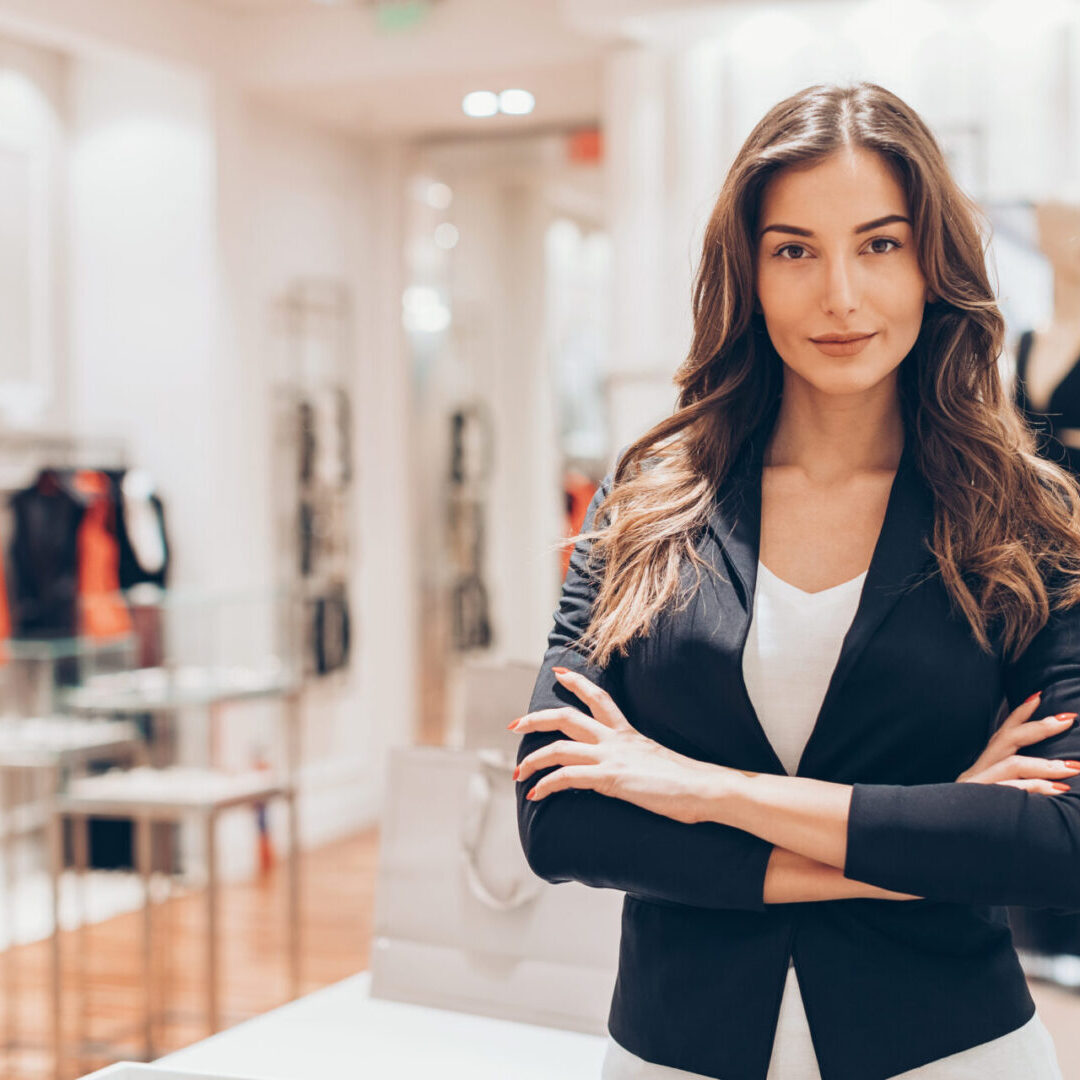 Beautiful woman standing with arms crossed in a fashion store